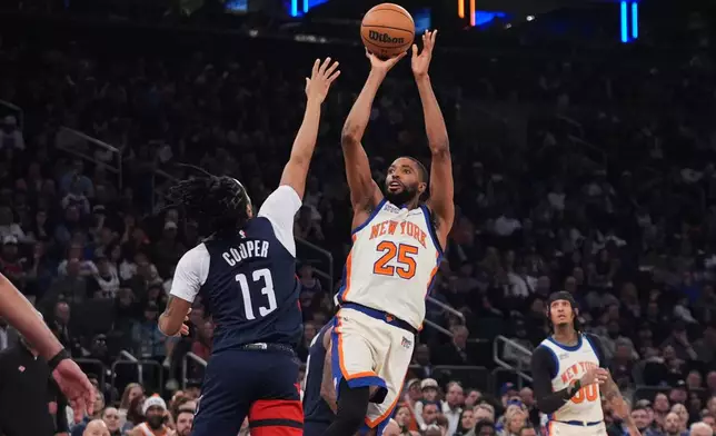 New York Knicks' Mikal Bridges (25) shoots over Washington Wizards' Sharife Cooper (13) during the first half of an NBA basketball game Sunday, March 22, 2026, in New York. (AP Photo/Frank Franklin II)