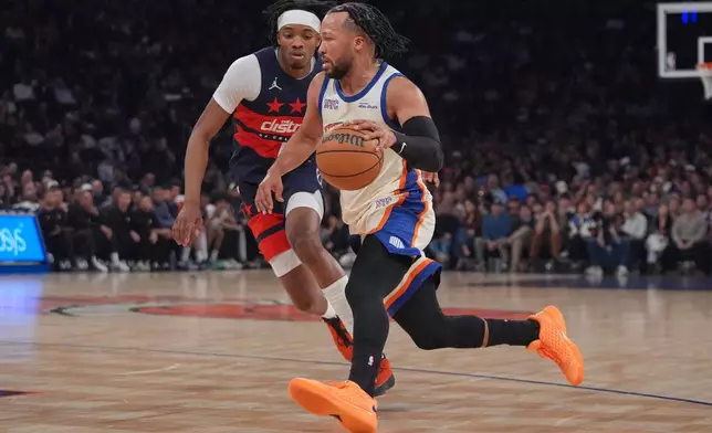 New York Knicks' Jalen Brunson, right, drives past Washington Wizards' Bilal Coulibaly during the first half of an NBA basketball game Sunday, March 22, 2026, in New York. (AP Photo/Frank Franklin II)