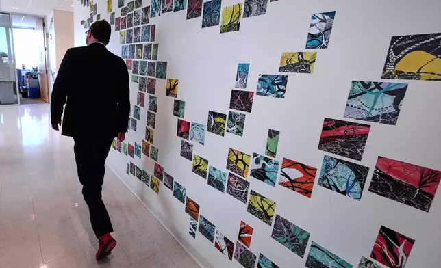Benjamin Neale, co-director of the Stanley Center for Psychiatric Research, walks through the laboratory floor at the Broad Institute, Tuesday, March 17, 2026, in Cambridge, Mass. (AP Photo/Charles Krupa)