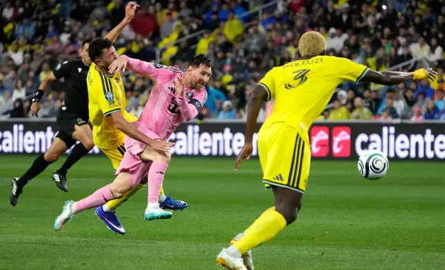 Inter Miami forward Lionel Messi, center, chases the ball as he is defended by Nashville SC midfielder Patrick Yazbek, left, and defender Maxwell Woledzi (3) in the first half of a CONCACAF Champions Cup Round of 16 soccer match Wednesday, March 11, 2026, in Nashville, Tenn. (AP Photo/Mark Humphrey)