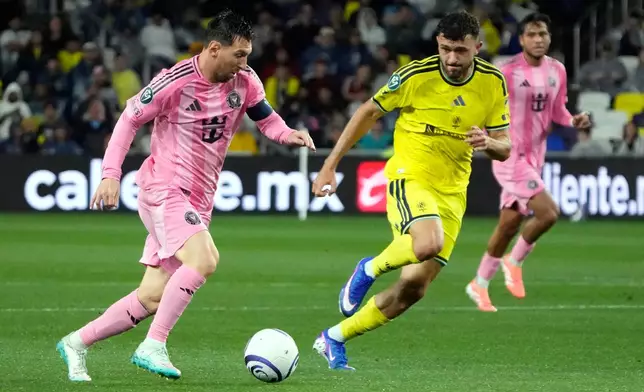 Inter Miami forward Lionel Messi, left, moves the ball against Nashville SC midfielder Patrick Yazbek in the first half of a CONCACAF Champions Cup Round of 16 soccer match Wednesday, March 11, 2026, in Nashville, Tenn. (AP Photo/Mark Humphrey)