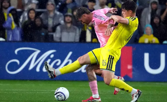 Inter Miami's Rodrigo de Paul, left, and Nashville SC's Matthew Corcoran, right, battler for the ball in the first half of a CONCACAF Champions Cup Round of 16 soccer match Wednesday, March 11, 2026, in Nashville, Tenn. (AP Photo/Mark Humphrey)