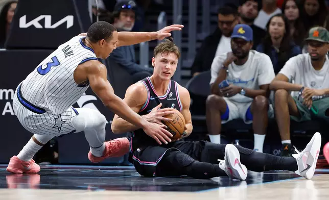 Orlando Magic guard Desmond Bane (3) defends Miami Heat guard Pelle Larsson, right, during the first half of an NBA basketball game in Miami, Saturday, March 14, 2026. (AP Photo/Rhona Wise)