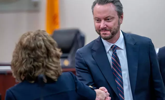 Linda Singer, an attorney representing the plaintiff, left, shakes hands with attorney Kevin Huff, representing Meta, after they made closing arguments, Monday, March 23, 2026, in state court, in Santa Fe, N.M., in a trial where the social media conglomerate is accused of misleading its users about how safe its platforms are for children. (Eddie Moore/The Albuquerque Journal via AP, Pool)
