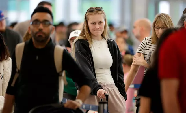 Air travelers endure long lines and two-hour wait times at the TSA security check point at Terminal E at the George Bush Intercontinental Airport Friday, March 20, 2026, in Houston. (AP Photo/Michael Wyke)