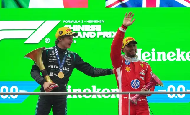 Race winner Mercedes driver Andrea Kimi Antonelli of Italy, left, celebrates on the podium with third placed Ferrari driver Lewis Hamilton of Britain after the Chinese Formula One Grand Prix race at the Shanghai International Circuit, in Shanghai, China, Sunday, March 15, 2026. (AP Photo/Andy Wong)