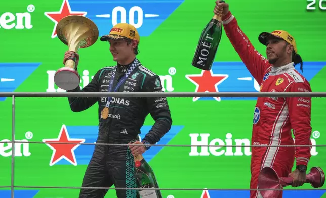 Race winner Mercedes driver Andrea Kimi Antonelli of Italy, left, celebrates on the podium with third placed Ferrari driver Lewis Hamilton of Britain after the Chinese Formula One Grand Prix race at the Shanghai International Circuit, in Shanghai, China, Sunday, March 15, 2026. (AP Photo/Andy Wong)