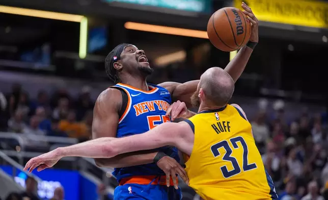 New York Knicks center Ariel Hukporti (55) grabs a rebound over Indiana Pacers center Jay Huff (32) during the first half of an NBA basketball game in Indianapolis, Friday, March 13, 2026. (AP Photo/Michael Conroy)