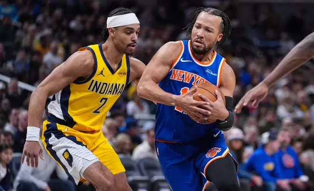 New York Knicks guard Jalen Brunson (11) drives on Indiana Pacers guard Andrew Nembhard (2) during the first half of an NBA basketball game in Indianapolis, Friday, March 13, 2026. (AP Photo/Michael Conroy)