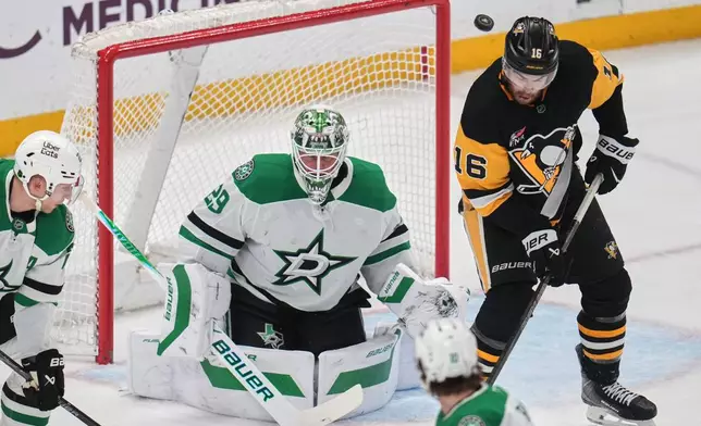 Pittsburgh Penguins' Justin Brazeau (16) deflects a shot in front of Dallas Stars goaltender Jake Oettinger (29) during the first period of an NHL hockey game in Pittsburgh, Saturday, March 28, 2026. (AP Photo/Gene J. Puskar)