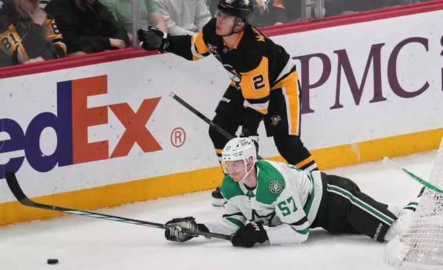 Pittsburgh Penguins' Rutger McGroarty (2) trips Dallas Stars' Tyler Myers (57) during the first period of an NHL hockey game in Pittsburgh, Saturday, March 28, 2026. (AP Photo/Gene J. Puskar)