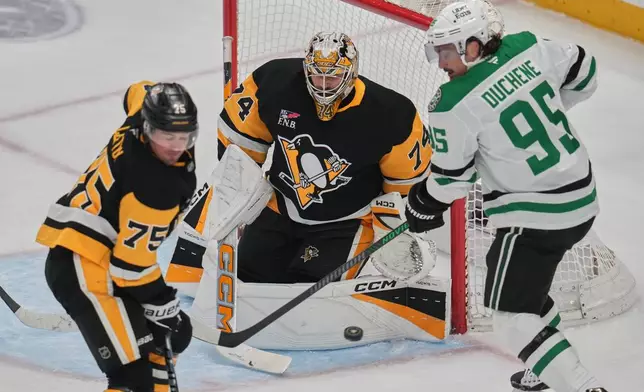 Pittsburgh Penguins goaltender Stuart Skinner (74) blocks a shot with Connor Clifton (75) defending as Dallas Stars' Matt Duchene (95) looks for the rebound during the first period of an NHL hockey game in Pittsburgh, Saturday, March 28, 2026. (AP Photo/Gene J. Puskar)