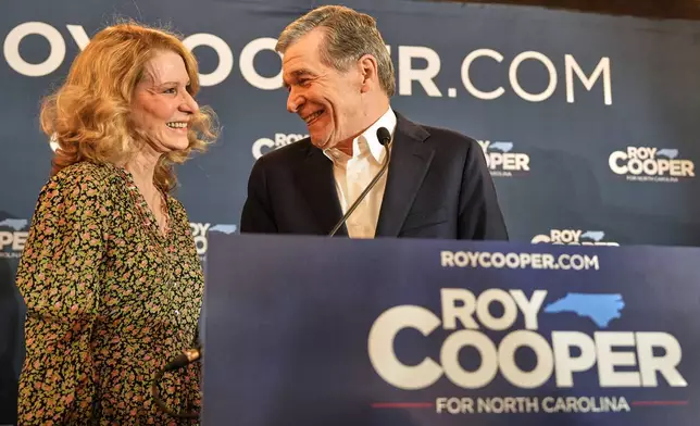North Carolina Democratic Senate candidate former Gov. Roy Cooper, right, shares a moment with his wife, Kristin Cooper, left, as he speaks at a primary election night watch party Tuesday, March 3, 2026, in Raleigh, N.C. (AP Photo/Matt Ramey)