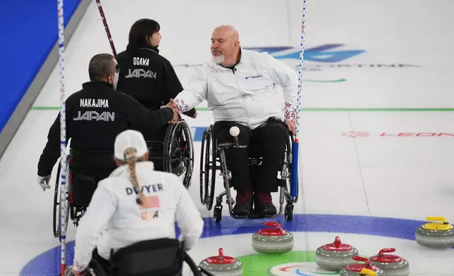 Steve Emt, right, and Laura Dwyer, of the United States, and Yoji Nakajima, left, and Aki Ogawa, of Japan, greet each other after their wheelchair curling mixed doubles round robin session at the 2026 Winter Paralympics, in Cortina d'Ampezzo, Italy, Thursday, March 5, 2026. (AP Photo/Evgeniy Maloletka)