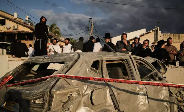 Ultra-Orthodox Jews gather at the site where several people were killed by an Iranian missile strike in Beit Shemesh, Israel Sunday, March 1, 2026. (AP Photo/Leo Correa)