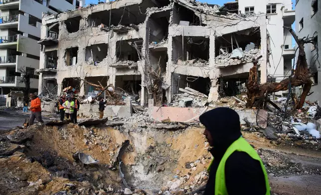 Rescue workers and military personnel survey the scene of a direct hit a day after an Iranian missile struck in Tel Aviv, Israel, Sunday, March 1, 2026. (AP Photo/Oded Balilty)