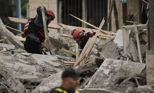 Rescue workers and military personnel operate at the scene where several people were killed in an Iranian missile strike in Beit Shemesh, Israel Sunday, March 1, 2026. (AP Photo/Leo Correa)