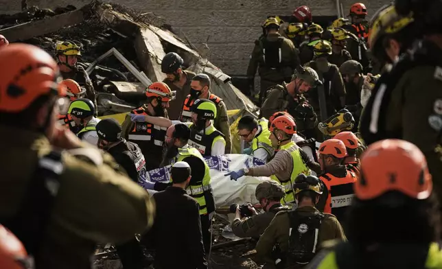Rescue workers and military personnel carry a body of a victim from the scene where several people were killed by an Iranian missile strike in Beit Shemesh, Israel Sunday, March 1, 2026. (AP Photo/Leo Correa)