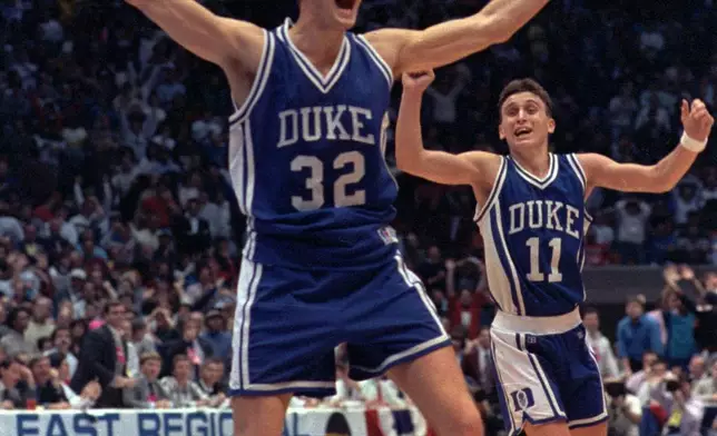 FILE - Duke's Christian Laettner, center, celebrates his game-winning shot against Connecticut in the NCAA East Regional Final at East Rutherford, N.J., on March 24, 1990. In the background is teammate Bobby Hurley. (AP Photo/Susan Ragan, File)