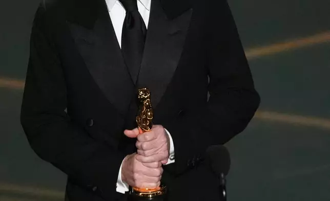 Paul Thomas Anderson accepts the award for writing (adapted screenplay) for "One Battle After Another" during the Oscars on Sunday, March 15, 2026, at the Dolby Theatre in Los Angeles. (AP Photo/Chris Pizzello)
