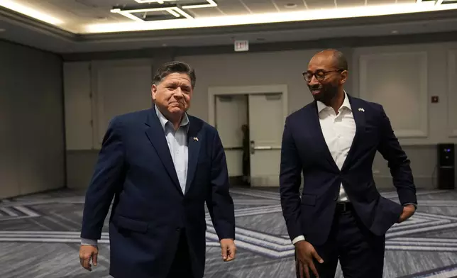 Illinois Gov. JB Pritzker, left, and running mate for lieutenant governor Christian Mitchell arrive for an interview, Wednesday, March 18, 2026, in Chicago. (AP Photo/Erin Hooley)