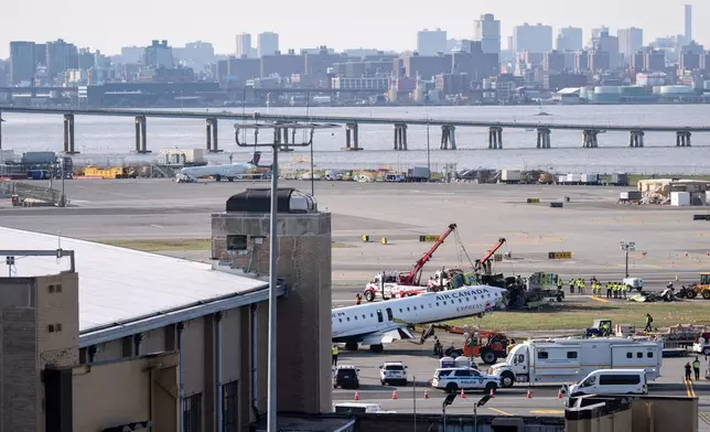 An airport maintenance crew moves the wreckage of an Air Canada Express jet, Wednesday, March 25, 2026, from the runway where it had collided with a Port Authority fire truck Sunday night at LaGuardia Airport, in New York. (AP Photo/Yuki Iwamura)