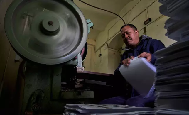 A staff member binds a voter list for distribution to various regions across the country ahead of the general election scheduled for March 5, at the Election Commission in Kathmandu, Nepal, Friday, Jan. 30, 2026. (AP Photo/Niranjan Shrestha,File)