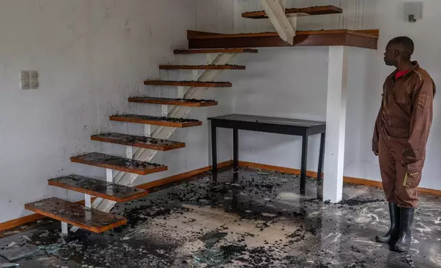 A man stands in a house hit by a drone strike in Goma, Democratic Republic of Congo, Wednesday, March 11, 2026. (AP Photo/Moses Sawasawa)