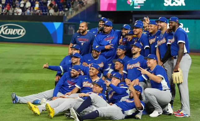 The Venezuela team poses for photos on the field before the championship game of the World Baseball Classic against the United States, Tuesday, March 17, 2026, in Miami. (AP Photo/Rebecca Blackwell)