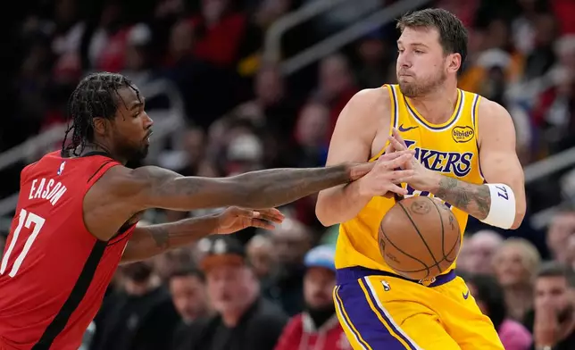 Houston Rockets' Tari Eason (17) knocks the ball away from Los Angeles Lakers' Luka Doncic during the second half of an NBA basketball game Monday, March 16, 2026, in Houston. (AP Photo/David J. Phillip)