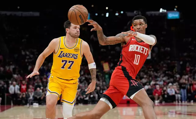 Houston Rockets' Jabari Smith Jr. (10) passes the ball as Los Angeles Lakers' Luka Doncic (77) defends during the second half of an NBA basketball game Monday, March 16, 2026, in Houston. (AP Photo/David J. Phillip)