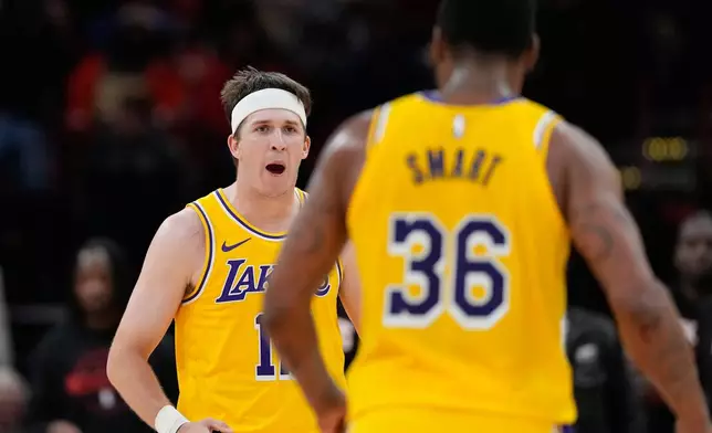 Los Angeles Lakers' Austin Reaves, left, celebrates with Marcus Smart (36) during the second half of an NBA basketball game against the Houston Rockets Monday, March 16, 2026, in Houston. (AP Photo/David J. Phillip)
