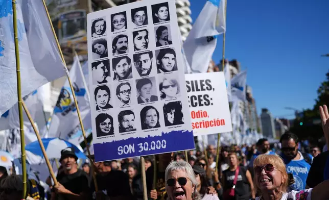A demonstrator rallies with a banner of people who disappeared during Argentina's military dictatorship (1976–1983) on the anniversary of the military coup that brought the military regime to power, in Buenos Aires, Argentina, Tuesday, March 24, 2026. (AP Photo/Rodrigo Abd)