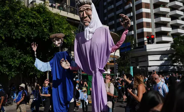 People rally with puppets depicting members of the Mothers of Plaza de Mayo human rights group on the anniversary of the military coup that brought the military regime to power, in Buenos Aires, Argentina, Tuesday, March 24, 2026. (AP Photo/Rodrigo Abd)