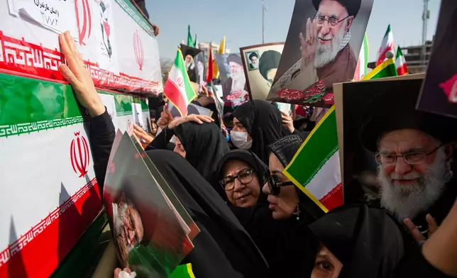 Some holding pictures of the late Iranian Supreme Leader Ayatollah Ali Khamenei, mourners reach out to coffins during a funeral for people killed during the ongoing U.S.–Israeli military campaign in Isfahan, Iran, Thursday, March 5, 2026. (Payman Shahsanaei/ISNA via AP)