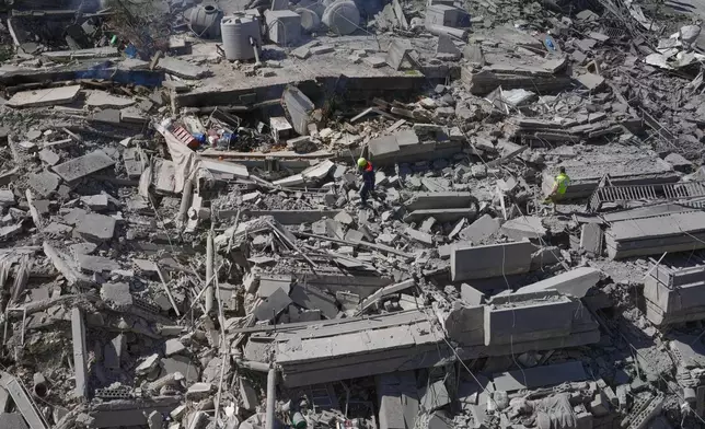 Rescue workers check a destroyed building that was hit by an Israeli airstrike in Nabatiyeh town, south Lebanon, Thursday, March 5, 2026. (AP Photo/Mohammed Zaatari)