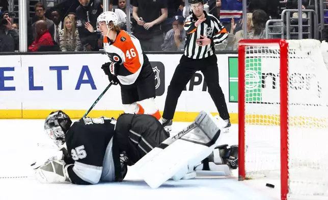 Philadelphia Flyers center Trevor Zegras (46) skates after scoring a goal as Los Angeles Kings goaltender Darcy Kuemper (35) looks on from the ice and referee Cody Beach, back right, gestures during a shootout of an NHL hockey game, Thursday, March 19, 2026, in Los Angeles. (AP Photo/Jessie Alcheh)