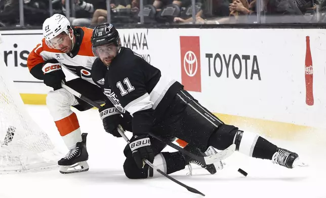 Los Angeles Kings center Anze Kopitar (11) and Philadelphia Flyers left wing Noah Cates, left, battle for the puck during the second period of an NHL hockey game, Thursday, March 19, 2026, in Los Angeles. (AP Photo/Jessie Alcheh)
