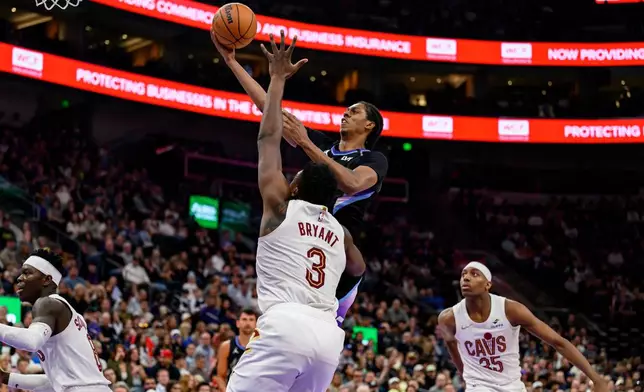 Utah Jazz forward Cody Williams, top center, goes to the basket for a layup over the defense of Cleveland Cavaliers center Thomas Bryant (3) during the first half of an NBA basketball game, Monday, March 30, 2026, in Salt Lake City. (AP Photo/Tyler Tate)