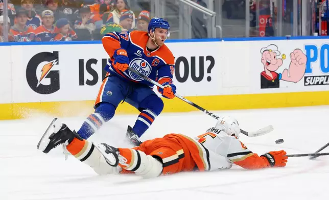 Anaheim Ducks' Jacob Trouba (65) slides in front of Edmonton Oilers' Connor McDavid (97) during the second period of an NHL hockey game in Edmonton, Alberta, Saturday March 28, 2026. (James Maclennan/The Canadian Press via AP)