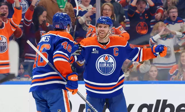 Edmonton Oilers' Connor McDavid (97) celebrates a goal with Max Jones (46) during the second period of an NHL hockey game against the Anaheim Ducks in Edmonton, Alberta, Saturday March 28, 2026. (James Maclennan/The Canadian Press via AP)