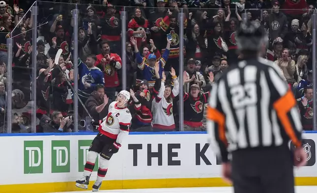 Fans celebrate Ottawa Senators' Brady Tkachuk's empty net goal against the Vancouver Canucks during the third period of an NHL hockey game, in Vancouver, on Monday, March 9, 2026. (Darryl Dyck/The Canadian Press via AP)