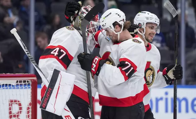 Ottawa Senators goalie James Reimer (47) and Ridly Greig (71) celebrate after Ottawa defeated the Vancouver Canucks 2-0 during an NHL hockey game, in Vancouver, on Monday, March 9, 2026. (Darryl Dyck/The Canadian Press via AP)