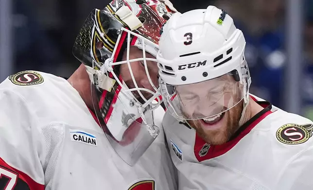 Ottawa Senators goalie James Reimer, left, and Nick Jensen celebrate after Ottawa defeated the Vancouver Canucks 2-0 during an NHL hockey game, in Vancouver, on Monday, March 9, 2026. (Darryl Dyck/The Canadian Press via AP)