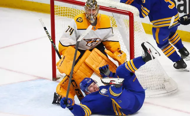 Buffalo Sabres defenseman Bowen Byram (4) falls in front of Nashville Predators goaltender Juuse Saros (74) during the third period of an NHL hockey game Saturday, March 7, 2026, in Buffalo, N.Y. (AP Photo/Jeffrey T. Barnes)