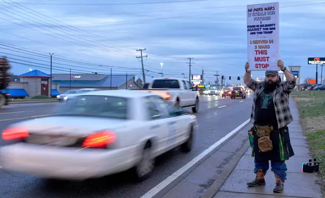 Army veteran Christopher William McFarland protests the war in Iran on Monday, March 2, 2026, in Clarksville, Tenn. (AP Photo/George Walker IV)
