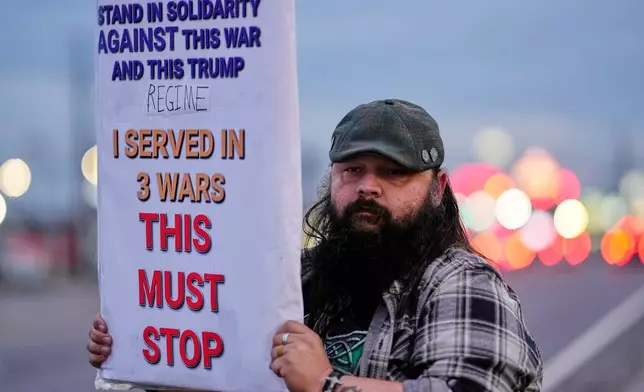 Army veteran Christopher William McFarland protests the war in Iran on Monday, March 2, 2026, in Clarksville, Tenn. (AP Photo/George Walker IV)