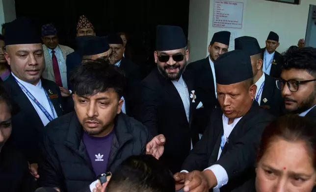 Balendra Shah, center with sun glasses, arrives for a swearing-in ceremony of newly elected members of the House of Representatives at the Federal Parliament in Kathmandu, Nepal, Thursday, March 26, 2026. (AP Photo/Niranjan Shrestha)