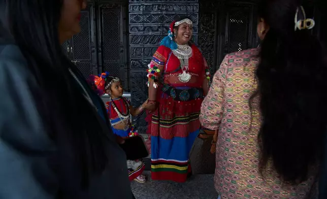 A newly elected member of the House of Representatives in traditional attire arrives with her daughter for a swearing-in ceremony at the Federal Parliament in Kathmandu, Nepal, Thursday, March 26, 2026. (AP Photo/Niranjan Shrestha)
