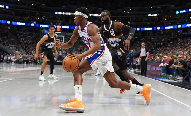 Philadelphia 76ers guard Vj Edgecombe, front, drives past Denver Nuggets guard Tim Hardaway Jr. in the first half of an NBA basketball game Tuesday, March 17, 2026, in Denver. (AP Photo/David Zalubowski)